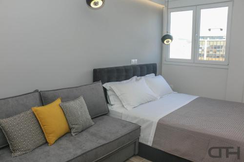 een slaapkamer met een bed en een bank bij New deluxe studio 1 downtown Thessaloniki-Fully equipped in Thessaloniki