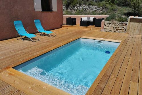 une piscine avec deux chaises et une terrasse en bois dans l'établissement Bédoin, maison cadre exceptionnel, à Bédoin