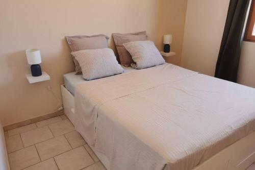 un grand lit blanc avec deux oreillers dessus dans l'établissement Bédoin, maison cadre exceptionnel, à Bédoin