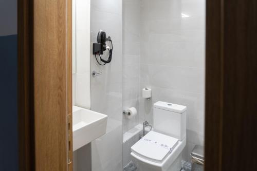 a white bathroom with a toilet and a sink at Alexandros in Giannitsa