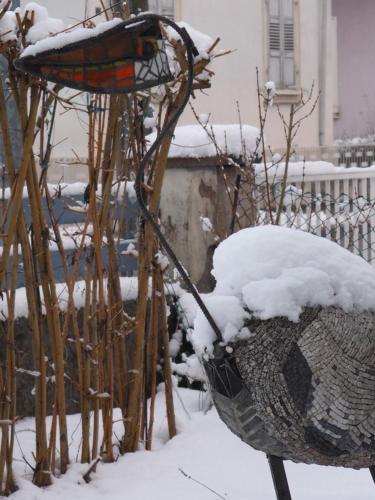 a bird feeder with snow on top of it at Gîte du héron in La Wantzenau