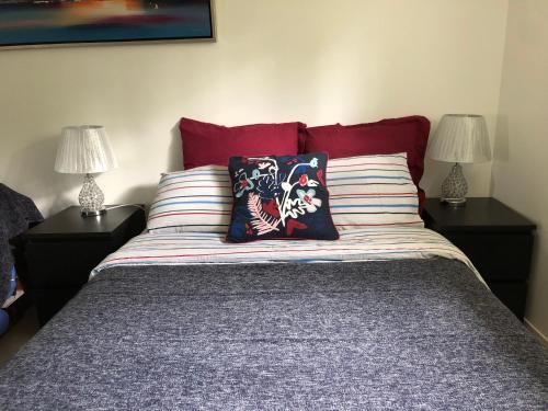 a bed with two lamps and two pillows on it at Room in house near Lycee International St Germain en Laye in Saint-Germain-en-Laye