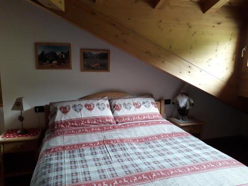 a bed in a bedroom with a wooden ceiling at Casa Vacanze Michela in Santa Caterina Valfurva
