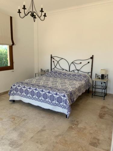 a bedroom with a bed and a chandelier at Spectacular views from this villa in Lapta in Kérynia