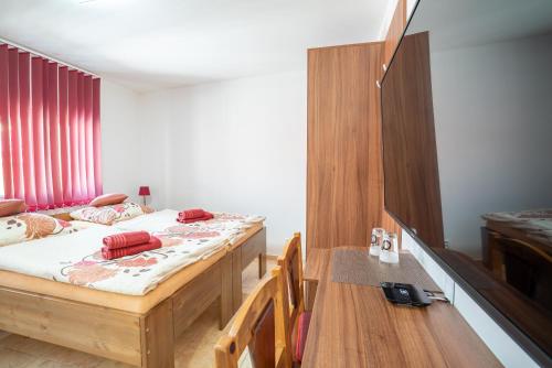 a bedroom with two beds and a wooden table at Šenk U Kovárny in Mariánské Lázně