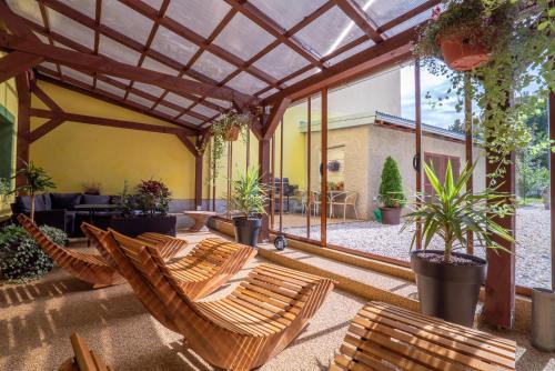an outdoor patio with chairs and plants and a large window at Šenk U Kovárny in Mariánské Lázně
