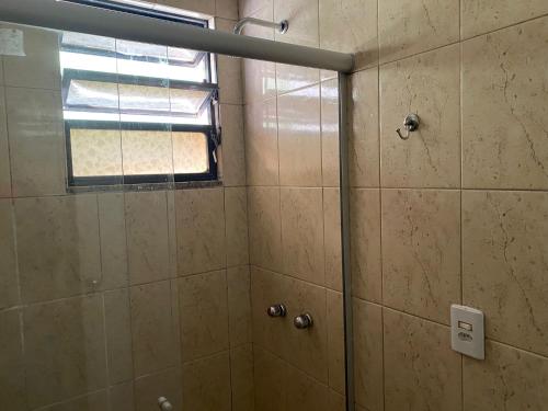 a shower with a glass door and a window at Ipanema Club Hostel in Rio de Janeiro