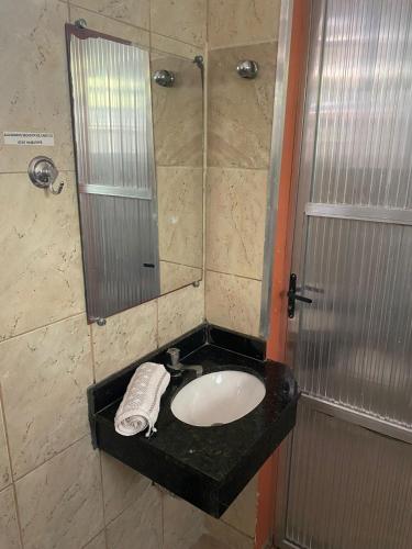 a bathroom with a sink and a shower with a mirror at Ipanema Club Hostel in Rio de Janeiro