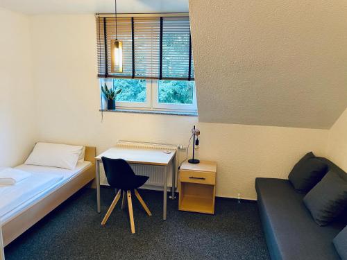 een kamer met een bed, een bureau en een bank bij Haus des Sports in Bad Kreuznach