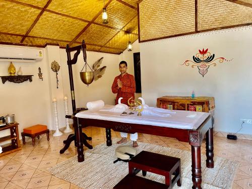 a man standing in a room with a table at Veda5 Wellness Retreat & Spa in Old Goa