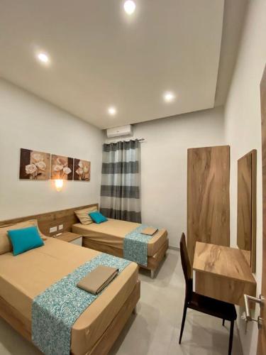 a room with two beds and a chair in it at Diamonds Luxury apartment - Julia in Marsalforn
