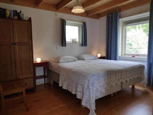 a bedroom with a bed with a white bedspread and a window at Elferink Hoeve in Woudenberg