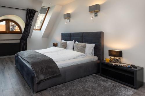 a bedroom with a large bed with a black headboard at Aparthotel New Lux in Wrocław