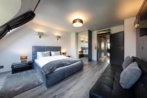 a bedroom with a large bed and a couch at Aparthotel New Lux in Wrocław