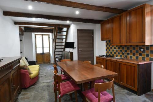 a kitchen with a wooden table and some chairs at Il Rustico in Ronco Canavese