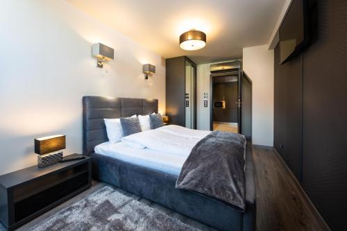a bedroom with a bed and a night stand with a lamp at Aparthotel New Lux in Wrocław