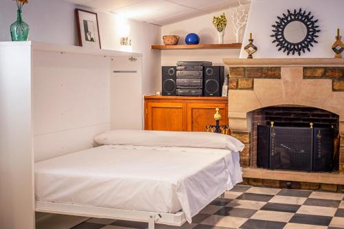 2 camas en una habitación con chimenea en attic 27, en Villanueva de los Infantes