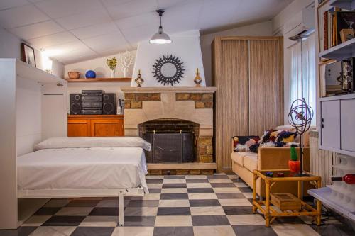 因凡特斯新鎮的住宿－attic 27，一间卧室设有壁炉、一张床和一张沙发