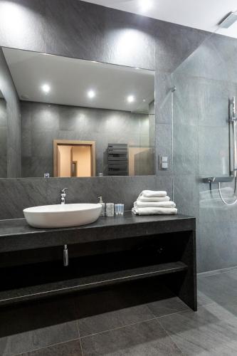 a bathroom with a sink and a large mirror at Aparthotel New Lux in Wrocław