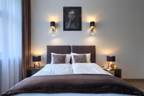 a bedroom with a large bed with lights on the wall at Aparthotel New Lux in Wrocław