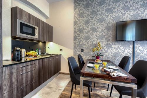 a kitchen and dining room with a table and chairs at Aparthotel New Lux in Wrocław