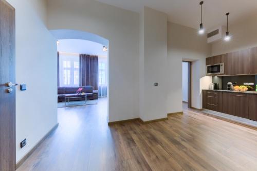 an empty living room with a couch and a kitchen at Aparthotel New Lux in Wrocław