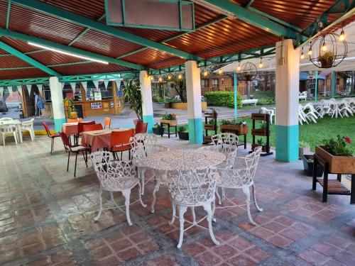 a patio with tables and chairs in a restaurant at Parque Girasoles Balneario & Cabañas in San Francisco del Rincón