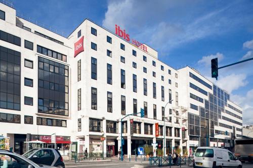 a white building on a city street with a traffic light at ibis Paris Pantin Eglise in Pantin