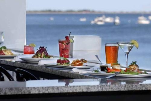 a table with plates of food and drinks at Newly Renovated Carriage House Near Town & Beaches in Madison