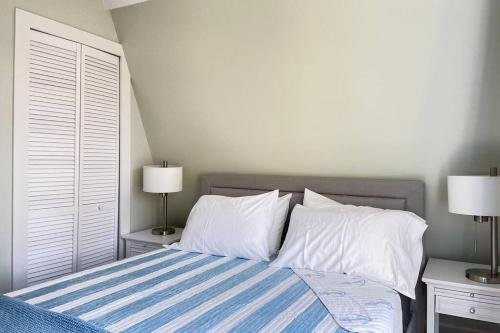 a bedroom with a bed with two pillows and two lamps at Newly Renovated Carriage House Near Town & Beaches in Madison