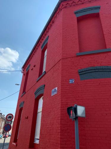 - un bâtiment en briques rouges avec des fenêtres donnant sur une rue dans l'établissement La Suite Classic, à Maubeuge