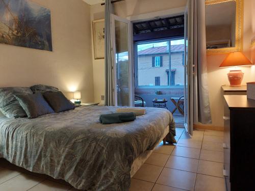 una camera con un grande letto e una grande finestra di Home Tranquille Dans la Cité du Mimosa - 2 étoiles - Axelle Loc'Appart a Mandelieu La Napoule