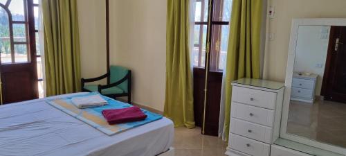 a bedroom with a bed with a dresser and a mirror at DREAM ISLAND Hotel in Luxor