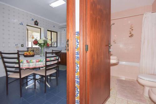 een keuken en eetkamer met een tafel en een badkamer bij Casa Golfinho (Norte) - Costa Nova in Costa Nova