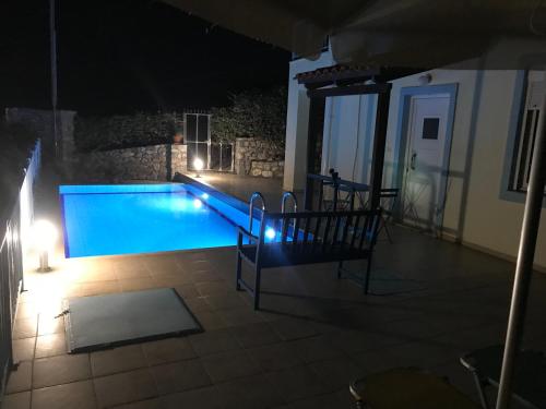 a swimming pool at night with a bench next to it at Breathtaking sea and Mountain views with Private pool, Peace full relaxing Villa with WiFi near Shops and Restaurants in Epáno Kefalás