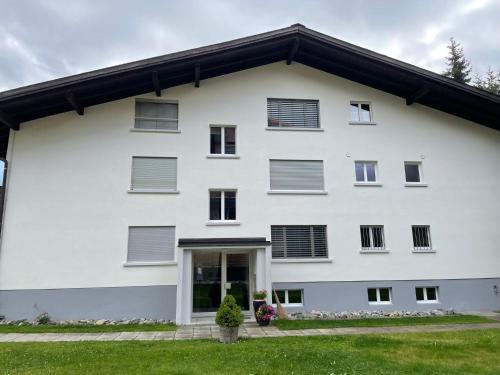 a white building with shuttered windows at Haus Pramalinis in Davos