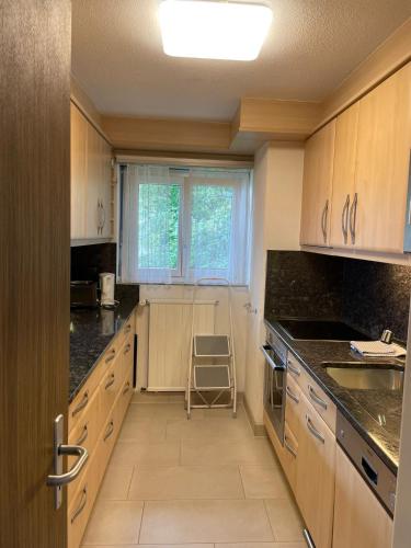 a kitchen with wooden cabinets and a chair in it at Haus Pramalinis in Davos