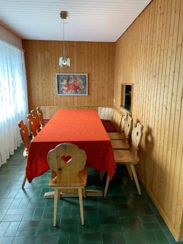 a dining room with a red table and chairs at Haus Pramalinis in Davos