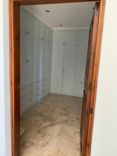 an empty room with white cabinets and a doorway at Spectacular views from this villa in Lapta in Kérynia