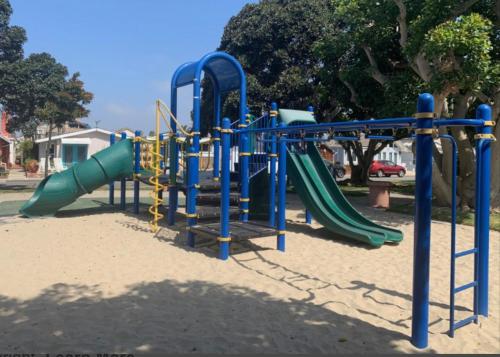 a playground with a slide in a park at Newport Channel Inn in Newport Beach