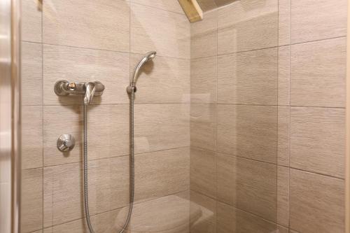 a shower with a shower head in a bathroom at Apartments Sport House Novakovic in Jahorina