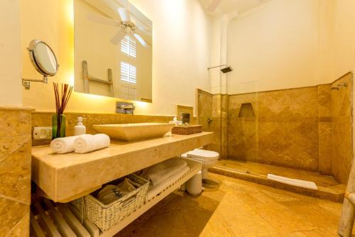 uma casa de banho com um lavatório, um WC e um espelho. em Casa Diluca Cartagena Hotel Boutique em Cartagena das Índias