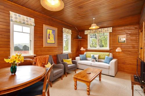 sala de estar con sofá y mesa en Otahuna Hideaway - Christchurch Holiday Homes, en Tai Tapu