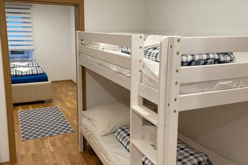 a couple of bunk beds in a room at 76 m² Ferienwohnung 2 Schlafzimmer, max. 7 Gäste in Kennelbach