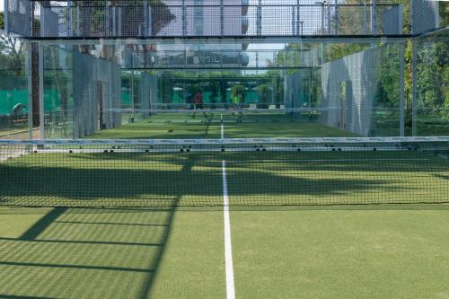 a tennis court with a net on a court at Villa Regina - MarePineta Resort in Milano Marittima