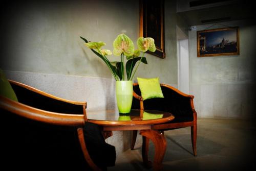 a vase with flowers sitting on a wooden table at Palazzo del Giglio in Venice