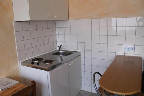 a small kitchen with a sink and a counter at City Apartment Hotel Hamburg in Hamburg