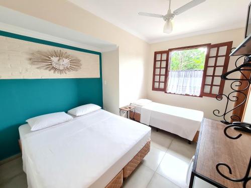 a bedroom with two beds and a blue wall at Pousada Nossa Senhora Aparecida in Águas de São Pedro