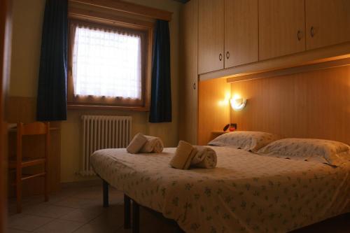 een slaapkamer met een bed met twee kussens erop bij Snowflake Apartment in Livigno