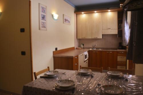 een keuken met een tafel met borden erop bij Snowflake Apartment in Livigno